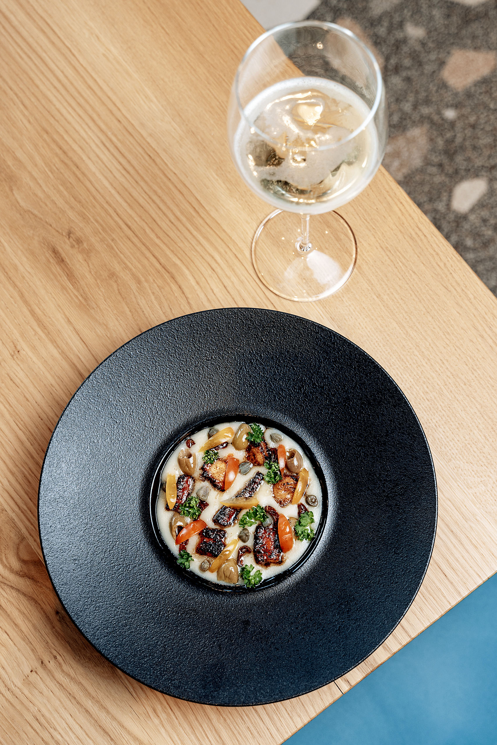 Piatto gourmet con calice di vino bianco